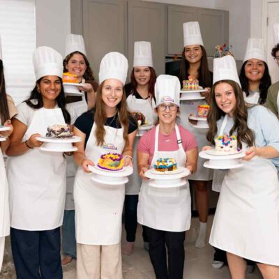 happy clients holding decorated cakes