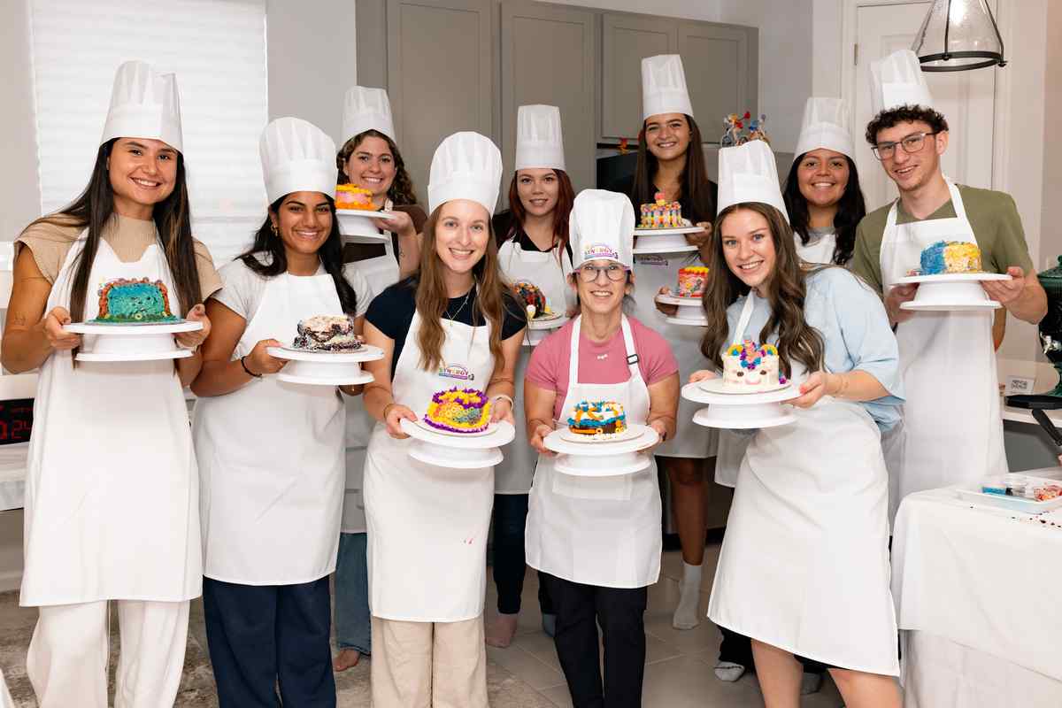 happy clients holding decorated cakes